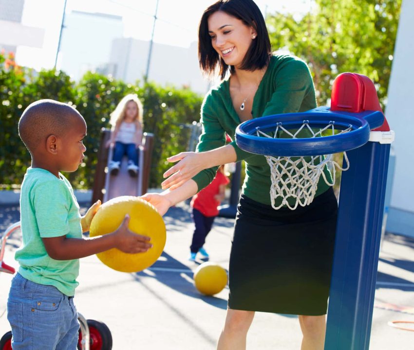 Teacher Supervising Breaktime At Elementary School